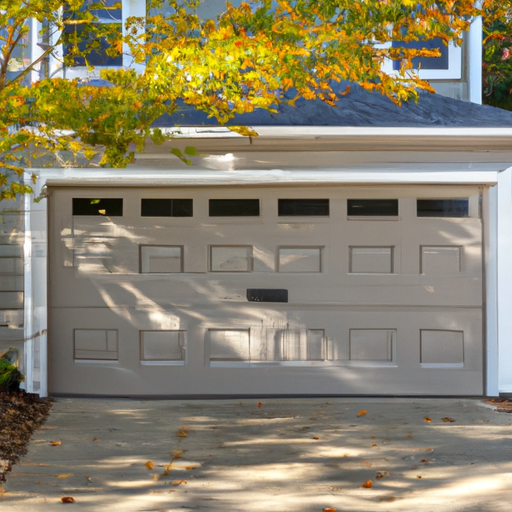 Closed insulated garage door on a suburban Medfield, MA home with autumn foliage, visible hardware and panel texture.